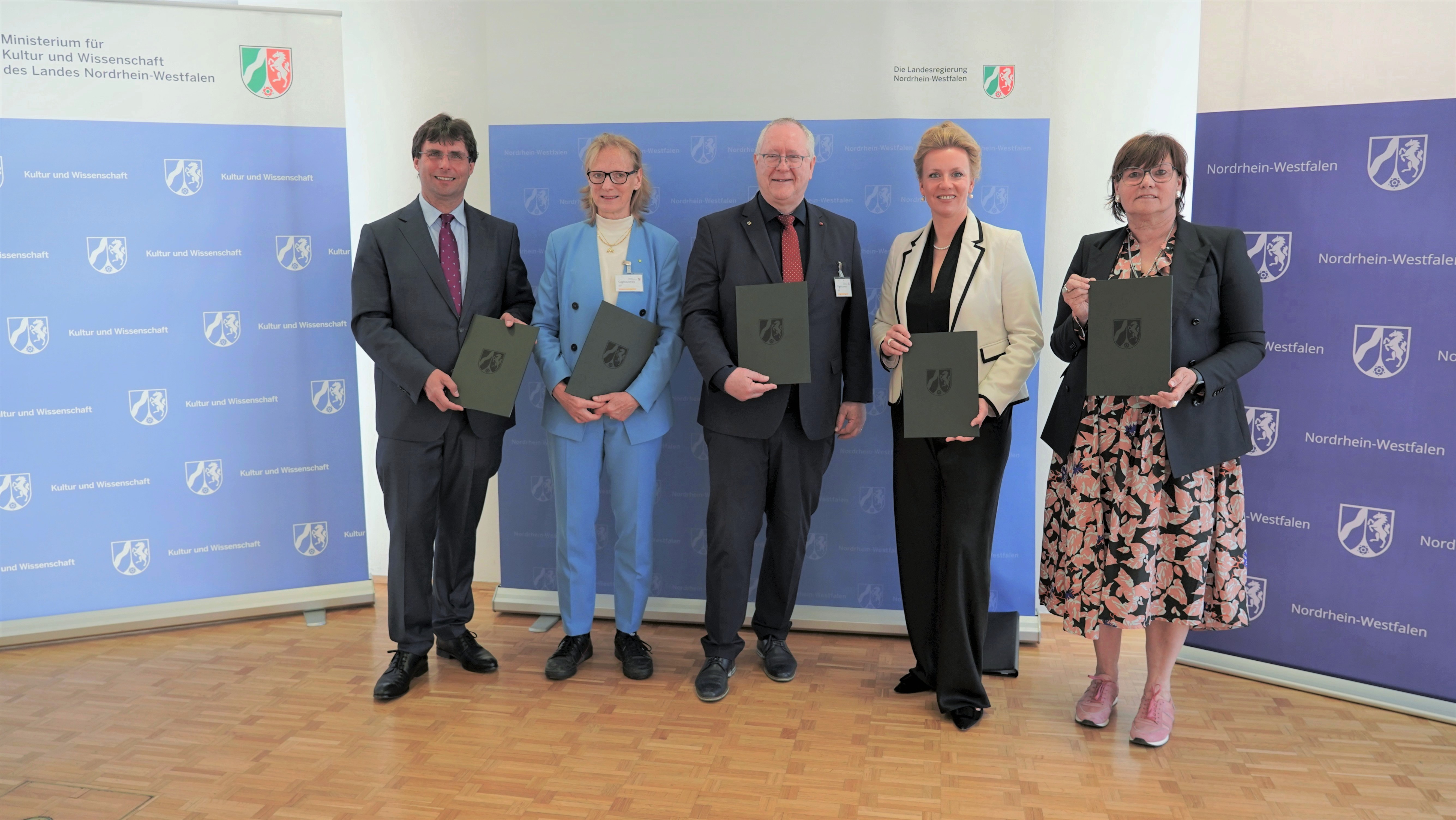 Landesregierung, Hochschulen und BLB als Gruppe vor Stellwänden