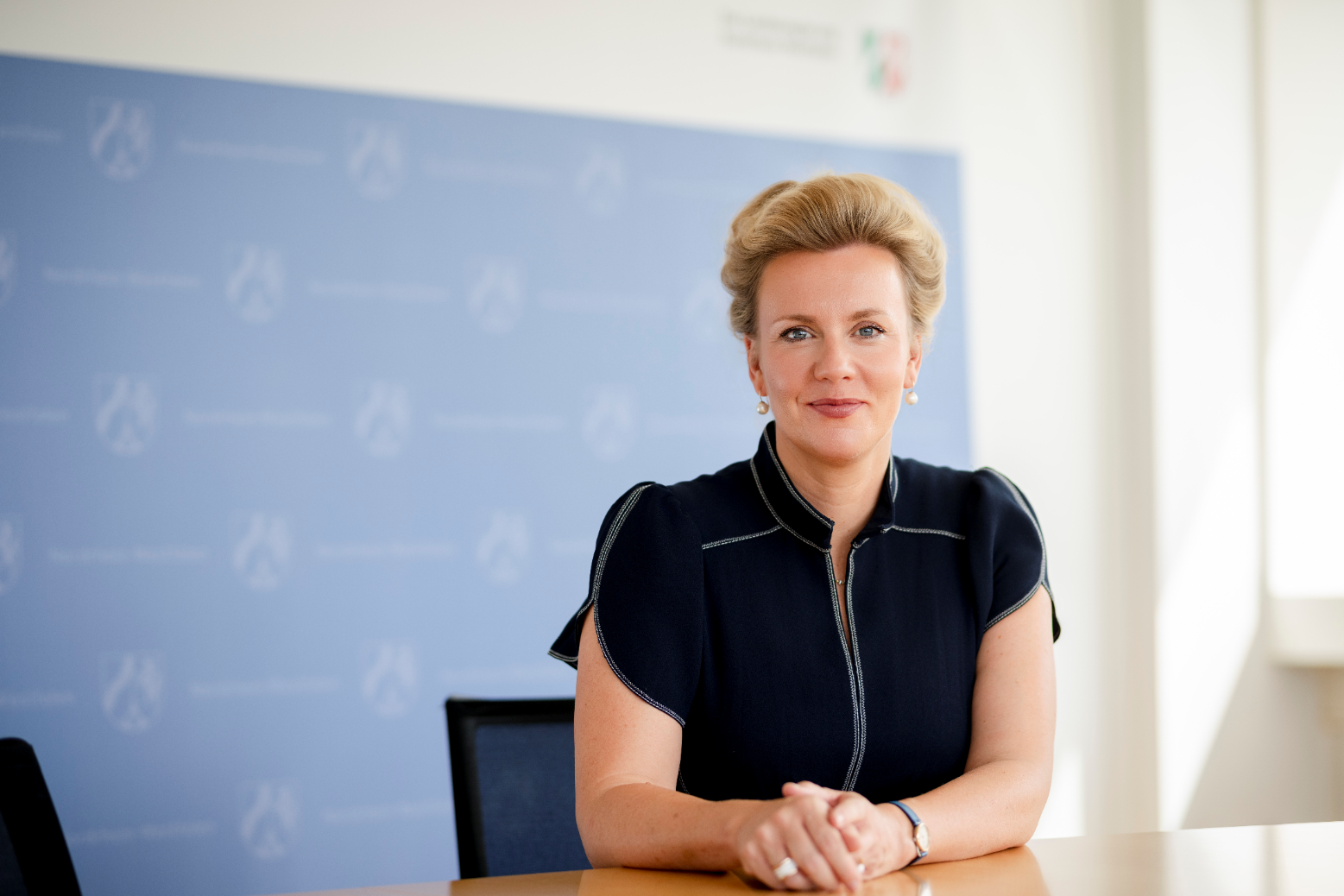 Ministerin Ina Brandes MdL sitzend vor einer Pressewand