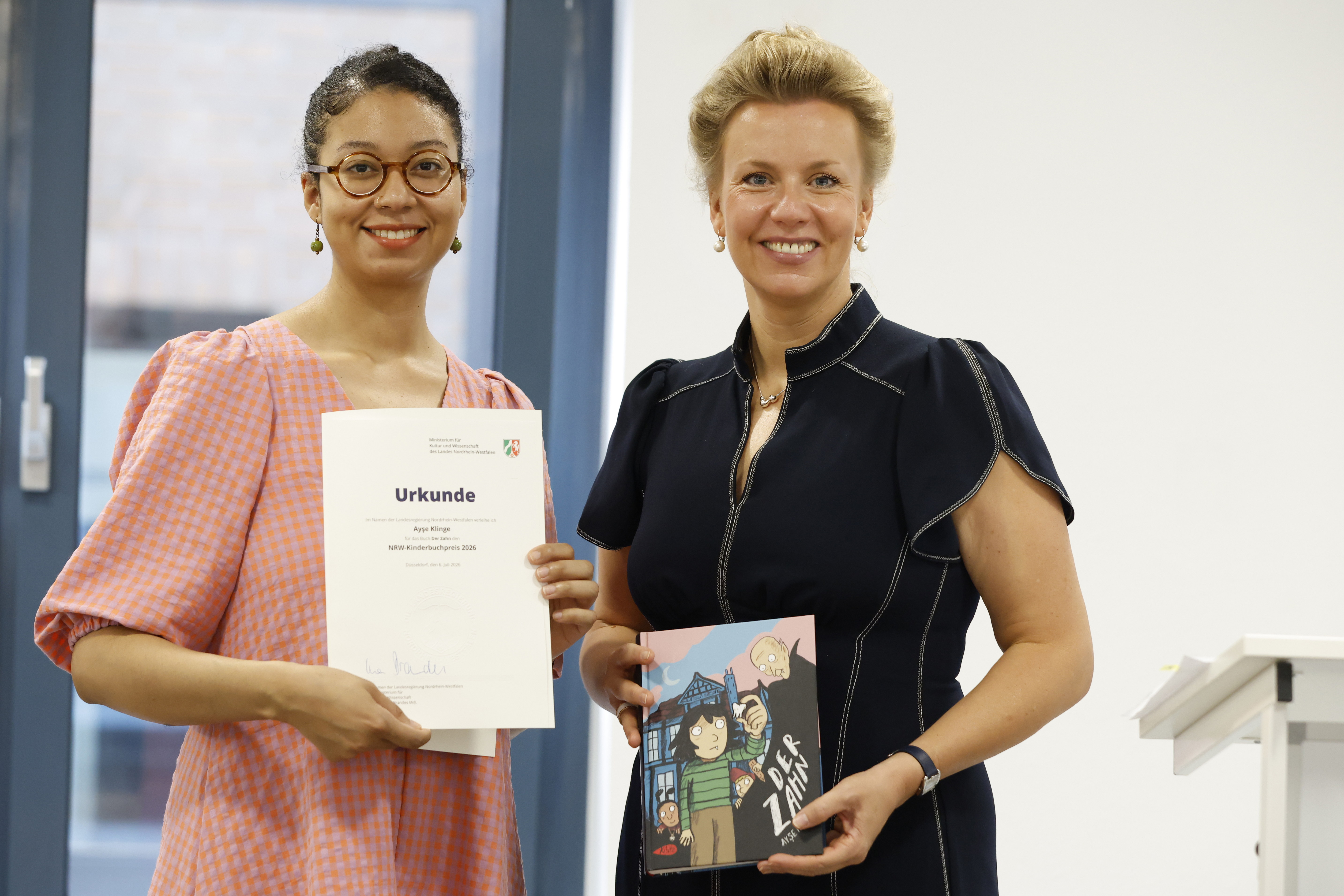 Autorin mit Urkunde, Ministerin mit Buch