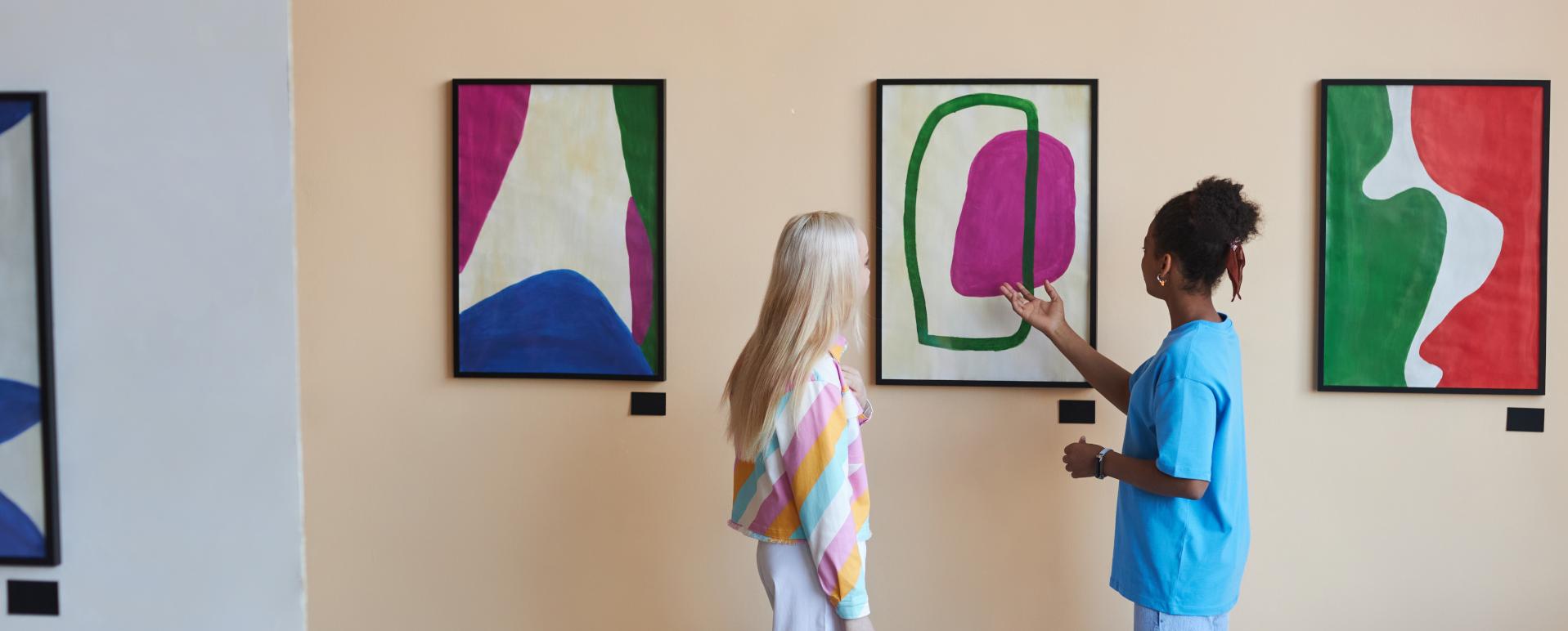 Zwei junge Frauen betrachten ein Kunstwerk in einem Museum