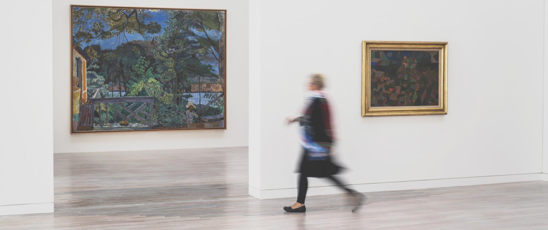 Frau mit Bewegungsunschärfte läuft durch eine Kunstausstellung
