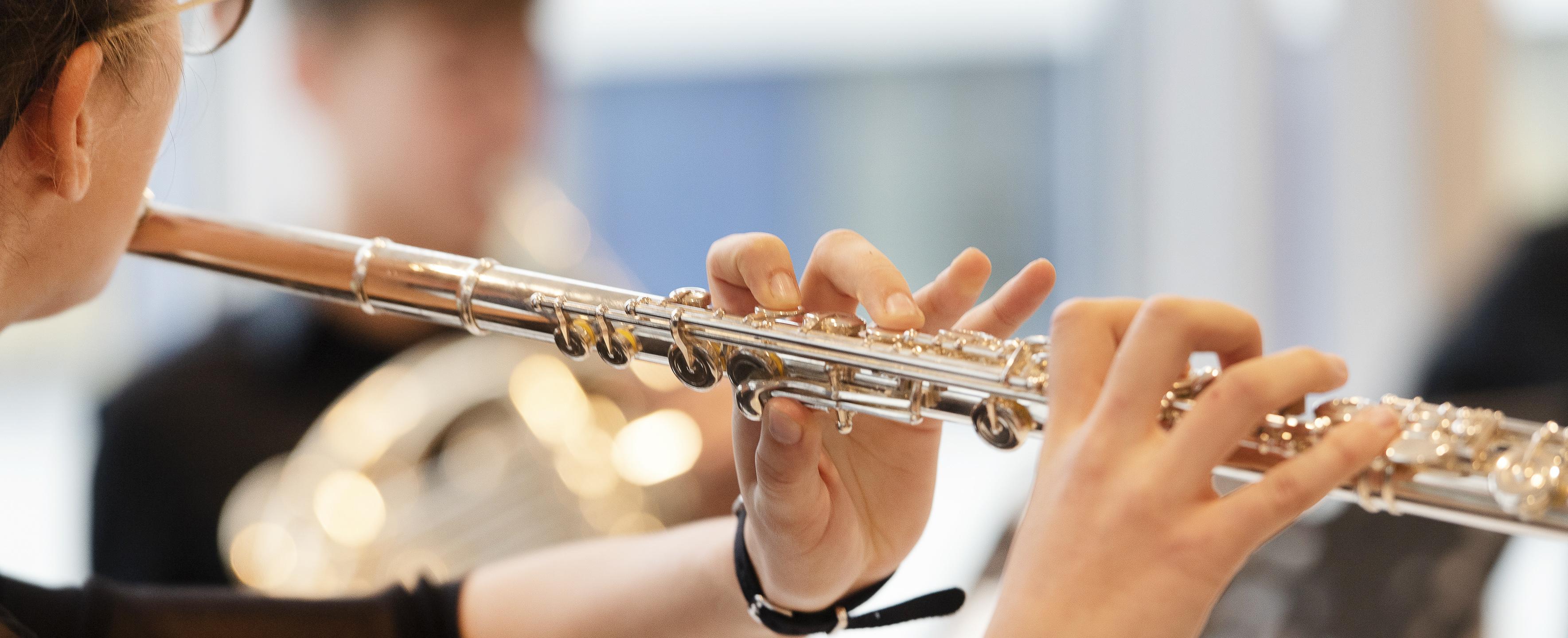 Eine Person spielt auf einer Querflöte