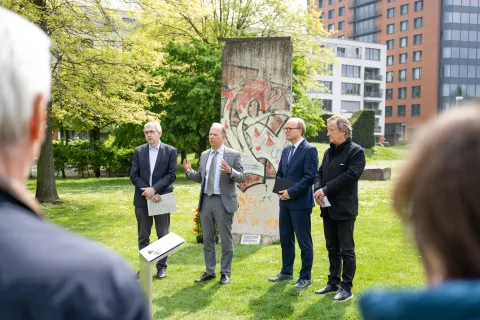 Vier Männer vor Gedenkstein