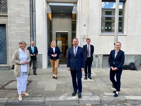 Sechs Personen vor einem Gebäude