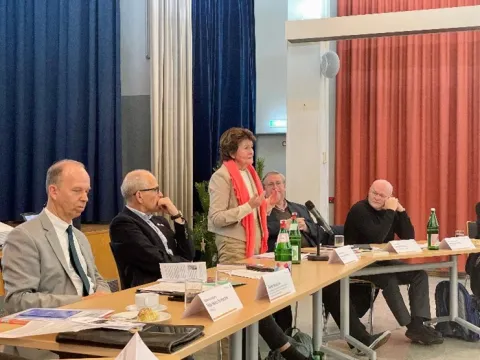 Frau spricht hinter einem Tisch