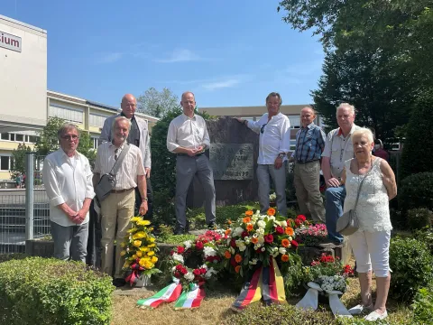 Gruppenfoto vor Gedenkstein mit Kränzen