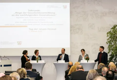 Mehrere Personen im Gespräch an Stehtischen