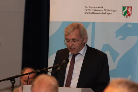 Mann an Pult vor Stellwand
