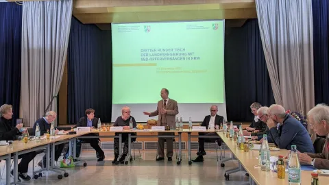 Redender Mann steht am Ende einer Tischformation