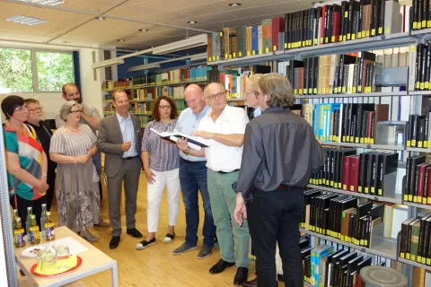 Menschengruppe vor einem Bücherregal