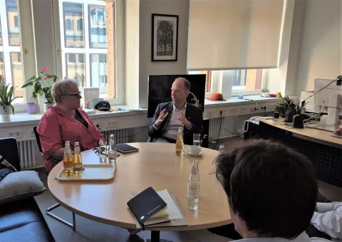 Zwei Menschen im Gespräch an einem runden Tisch