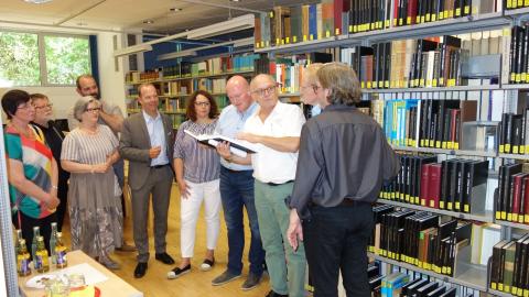Dr. Hans-Jakob Tebarth zeigt den Sitzungsteilnehmenden die Martin-Opitz-Bibliothek