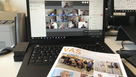 aufgeklappter Laptop auf dem man eine virtuelle Konferenz sieht