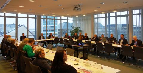 Tagung des Landesbeirats, Männer und Frauen sitzen sich an u-förmig angeordneten Tischen gegenüber