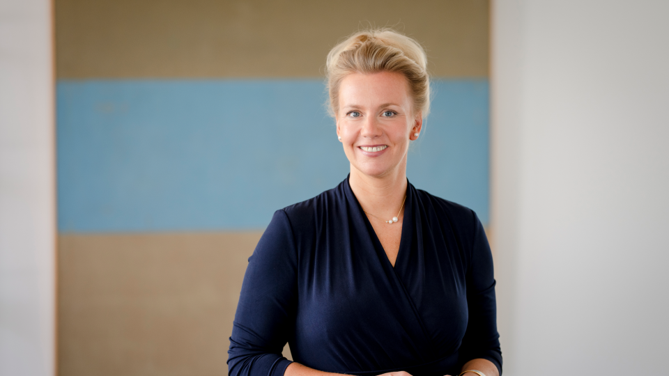 Frau (Ministerin Ina Brandes) vor einem Gemälde im Hintergrund