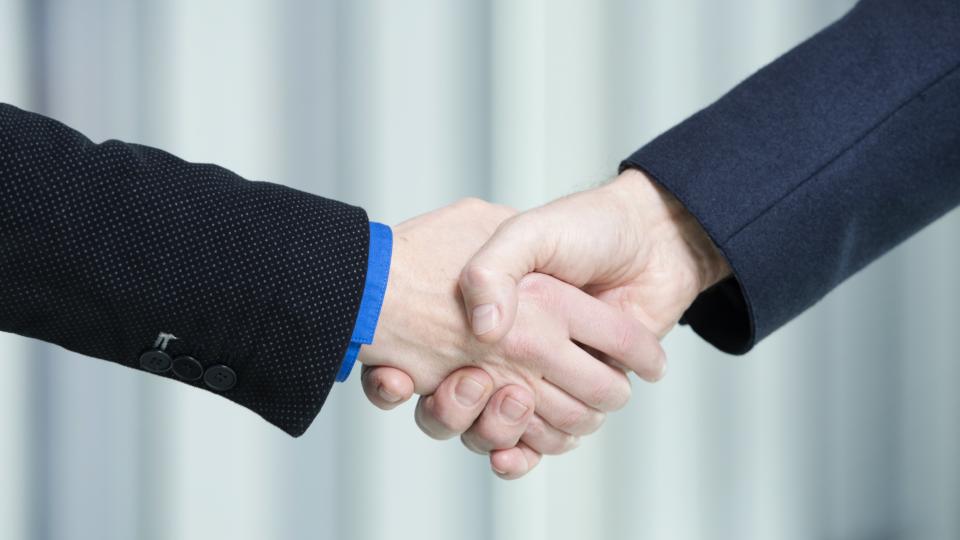 Zwei Arme, die sich die Hand geben