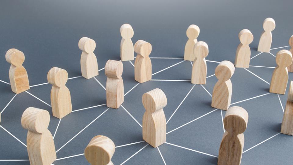 Holzfiguren, die durch Striche vernetzt sind