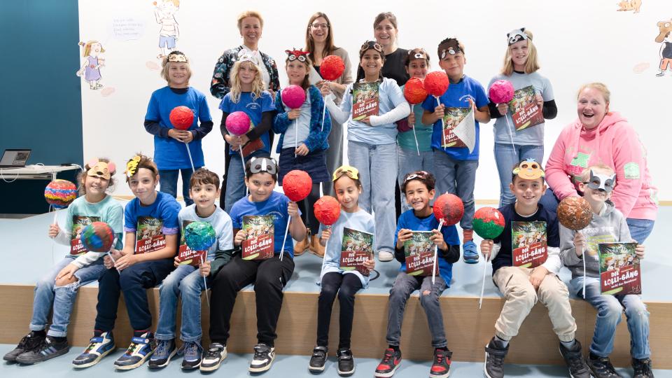 Die beiden Preisträgerinnen Susanne Göhlich und Charlotte Inden und Ministerin Ina Brandes zusammen mit den Schülerinnen und Schülern der Katholischen Grundschule Uedding in Mönchengladbach 
