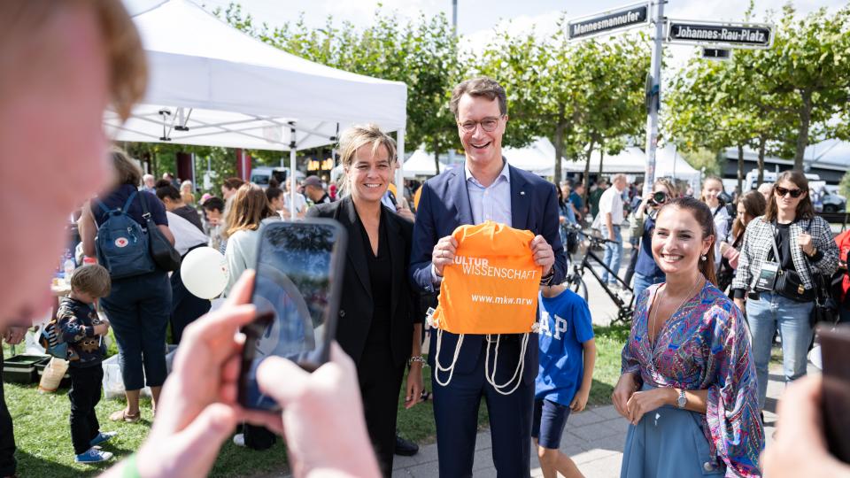 Ministerpräsident Wüst mit Mona Neubaur und Frau Staatssekretärin am Stand des MKW