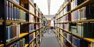 Gang in einer Bibliothek mit vielen Büchern zur linken und rechten Seite