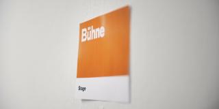 Orangenes Wandschild mit der Aufschrift "Bühne"