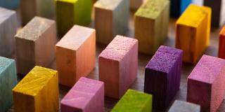 Bunte Holz-Klötzchen in Reihen aufgestellt