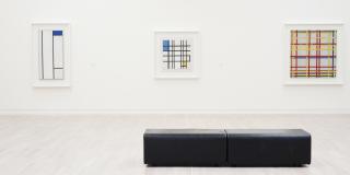 Leere Sitzbank vor eine Wand mit Gemälden