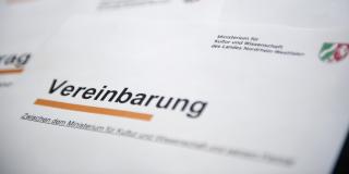 Auf einem Blatt mit dem Logo des Ministeriums steht das Wort Vereinbarung