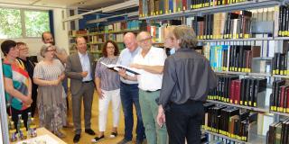 Dr. Hans-Jakob Tebarth zeigt den Sitzungsteilnehmenden die Martin-Opitz-Bibliothek