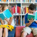 Ein Mädchen und ein Junge lesen ein Buch in einer Bibliothek