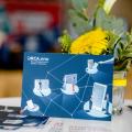 ORCA.nrw-Postkarte auf Tisch mit Blumendeko